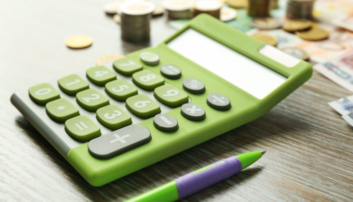Money,Concept.,Green,Calculator,With,Banknotes,And,Coins,On,Wooden